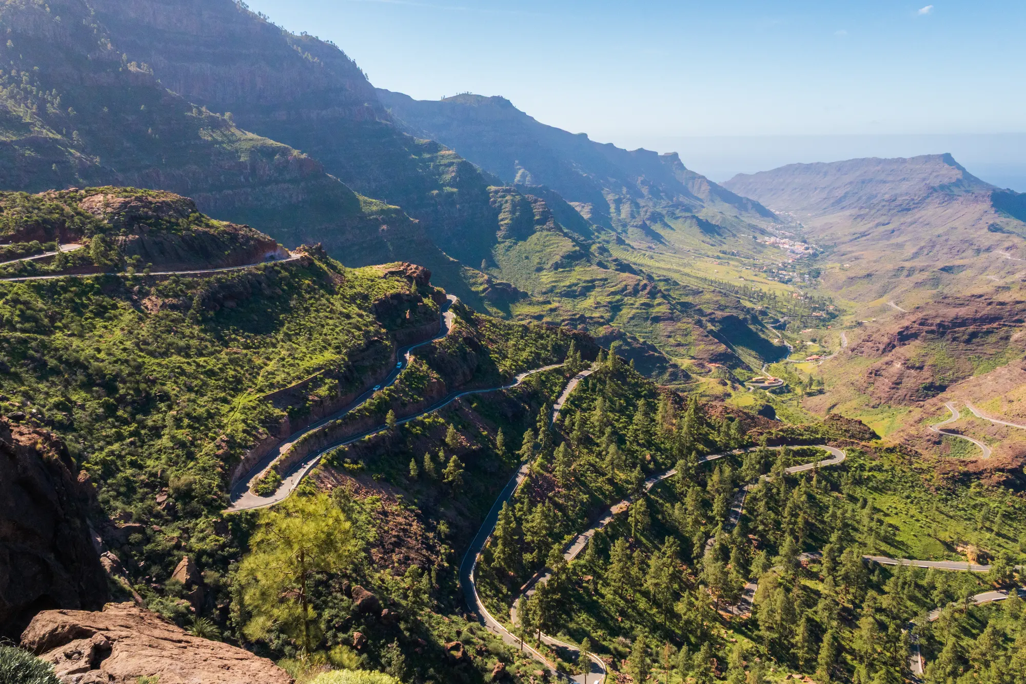 Switchbacks winding down a green volcanic valley in Gran Canaria